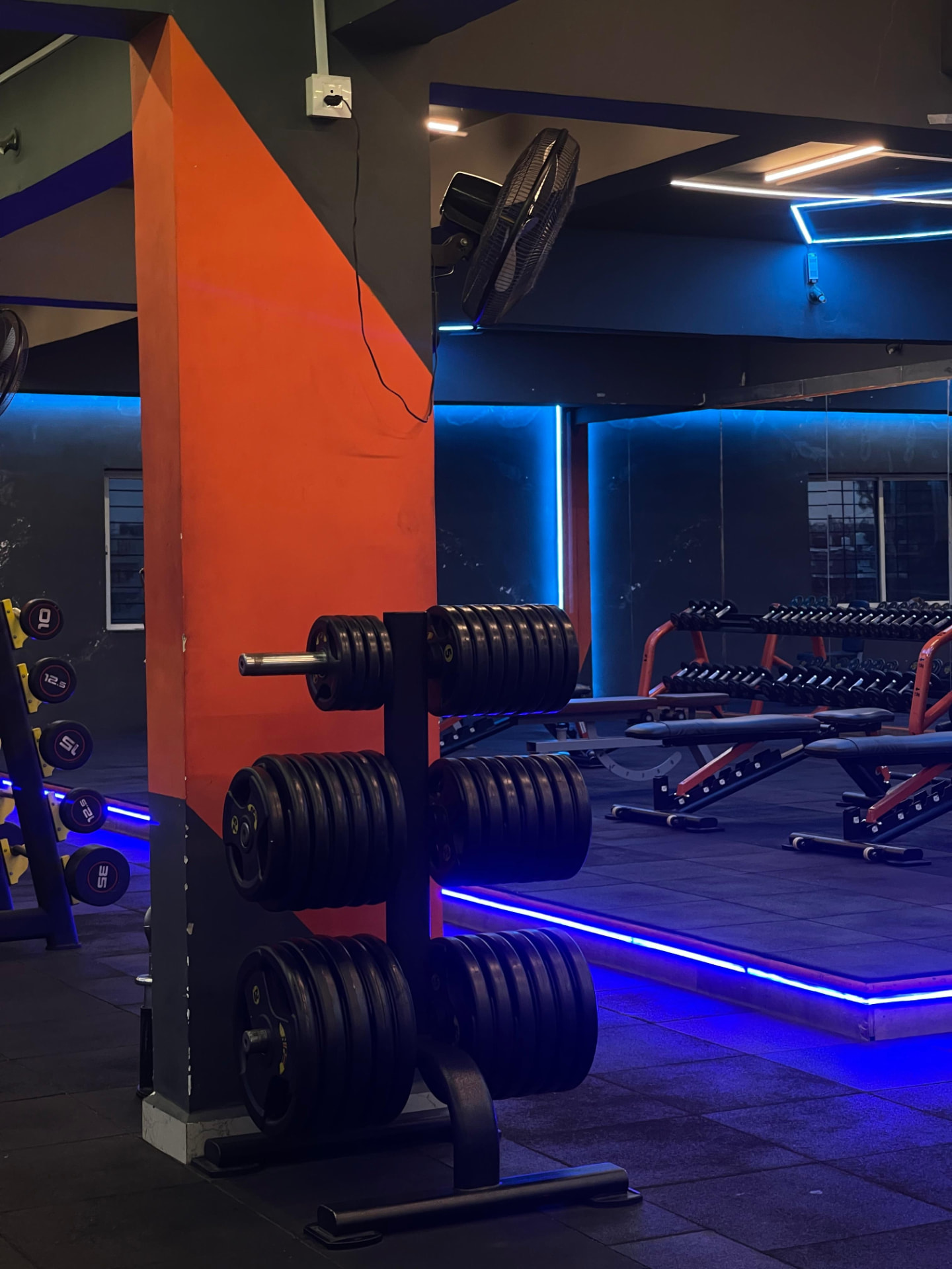Strength training area with dumbbells, benches and weight plates at SK Fitness Gym Kharadi